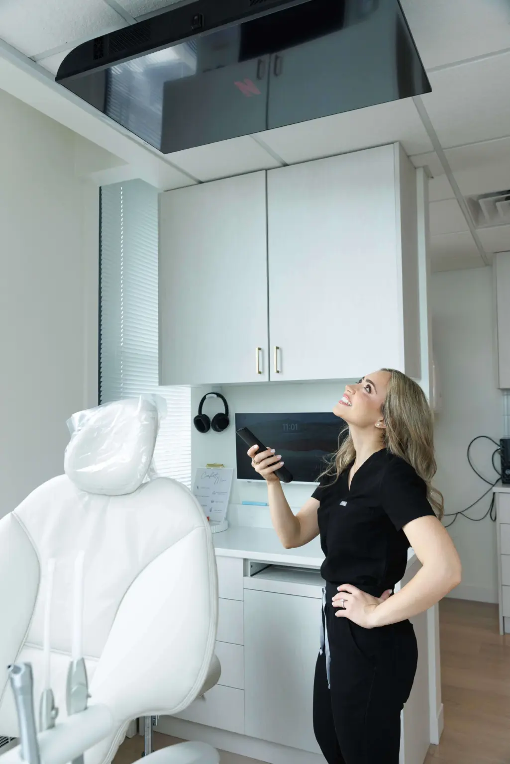 Dental operatory at EVER Dental Studio in downtown Chicago with a ceiling-mounted TV, noise-canceling headphones and comfort menu