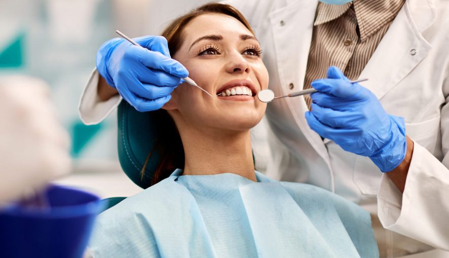 Young smiling woman having dental exam at dentist's office.